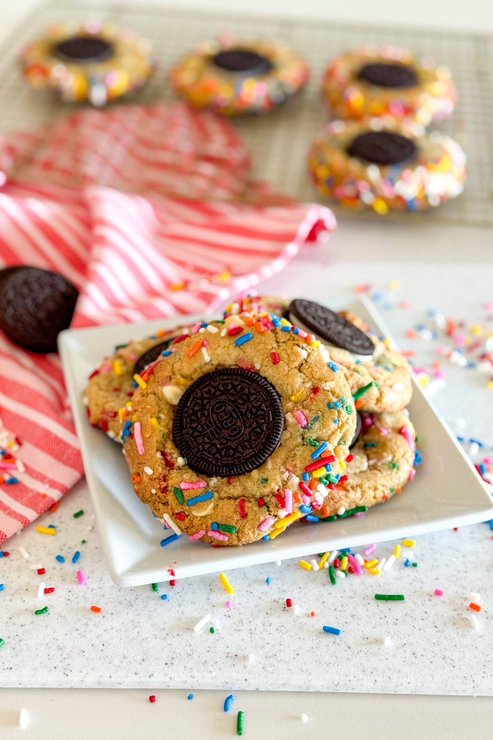 Freshly baked funfetti cookies with white chocolate chips and an Oreo center, displayed on a plate