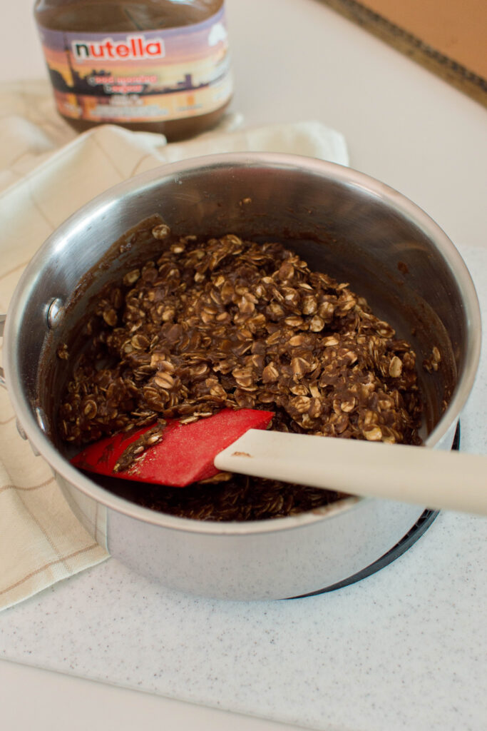 Butter, milk, sugar, and cocoa melting together in a saucepan for no-bake cookies.