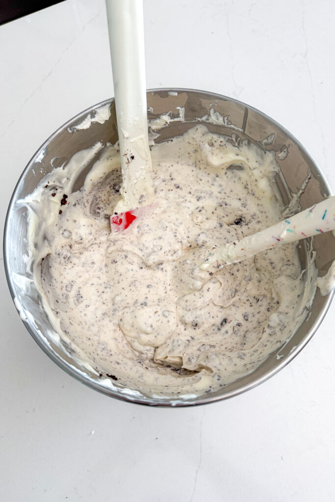 Mixing whipping cream and condensed milk in a stainless steel bowl to make Homemade Brownie Ice Cream