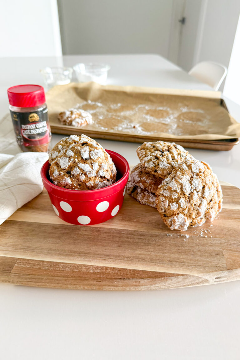Coffee Crinkle Cookies styled on a wooden board with instant coffee in the background.
