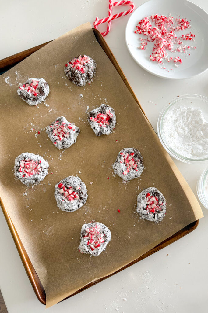 Overhead view of peppermint mocha crinkle cookie dough balls on a baking sheet