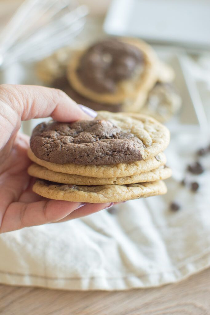 Hand holding a stack of soft marbled chocolate chip cookies