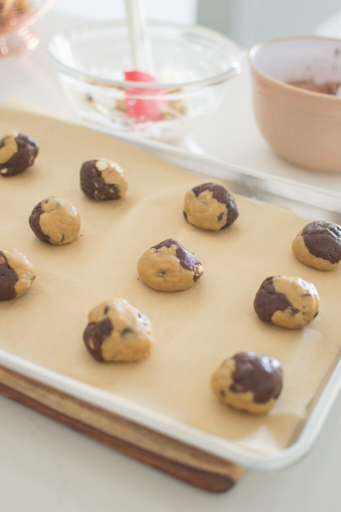 Marbled chocolate and vanilla cookie dough scooped onto baking tray