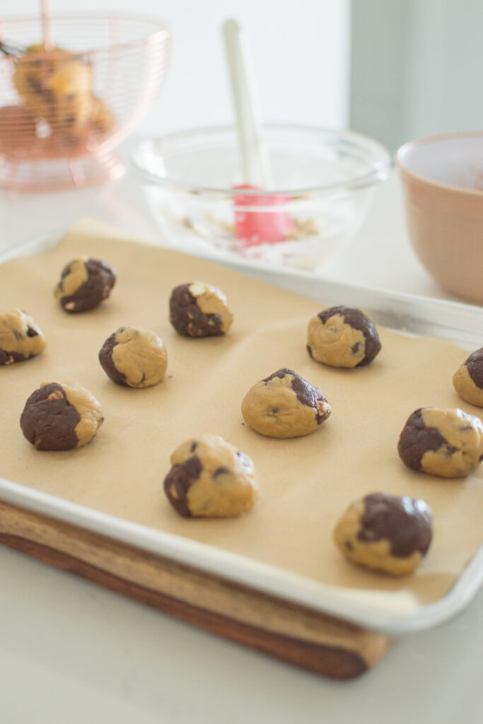 Baking tray filled with marbled chocolate chip cookie dough portions