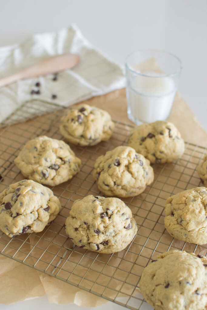 Oversized chocolate chip cookies arranged on a cooling rack