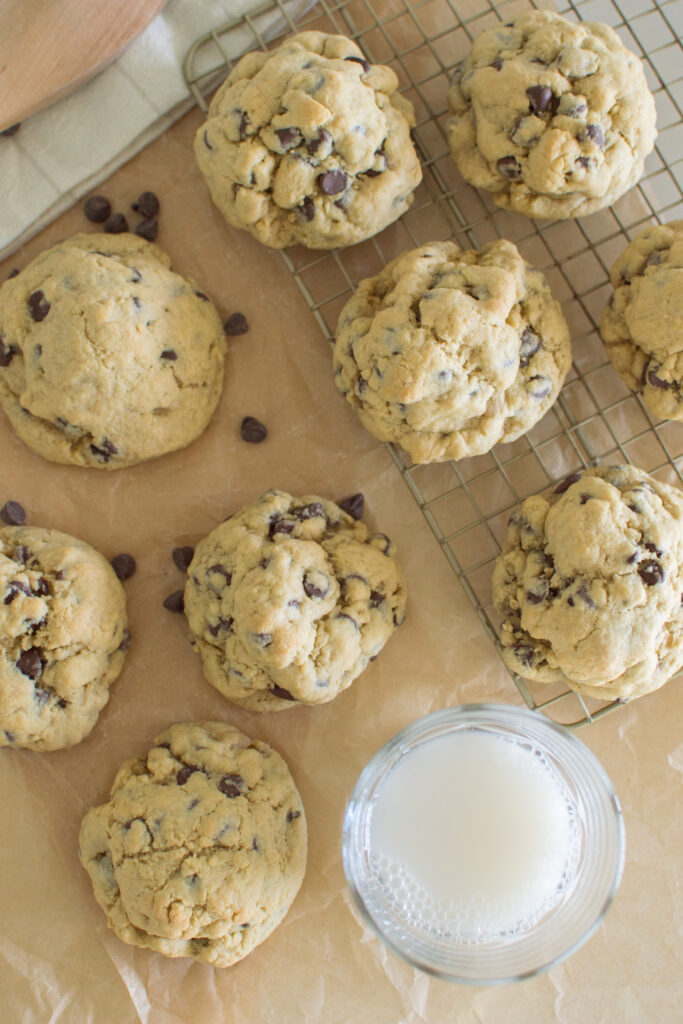 Freshly baked oversized chocolate chip cookies cooling on baking sheet